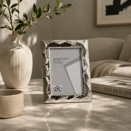 Ασημένιο επάργυρο κάδρο φωτογραφιών 13x18cm με 3D γωνίες σε μαρμάρινο τραπέζι σαλονιού με λευκό ραβδωτό βάζο με ελιά και βιβλίο Live Beautiful - VassoHome