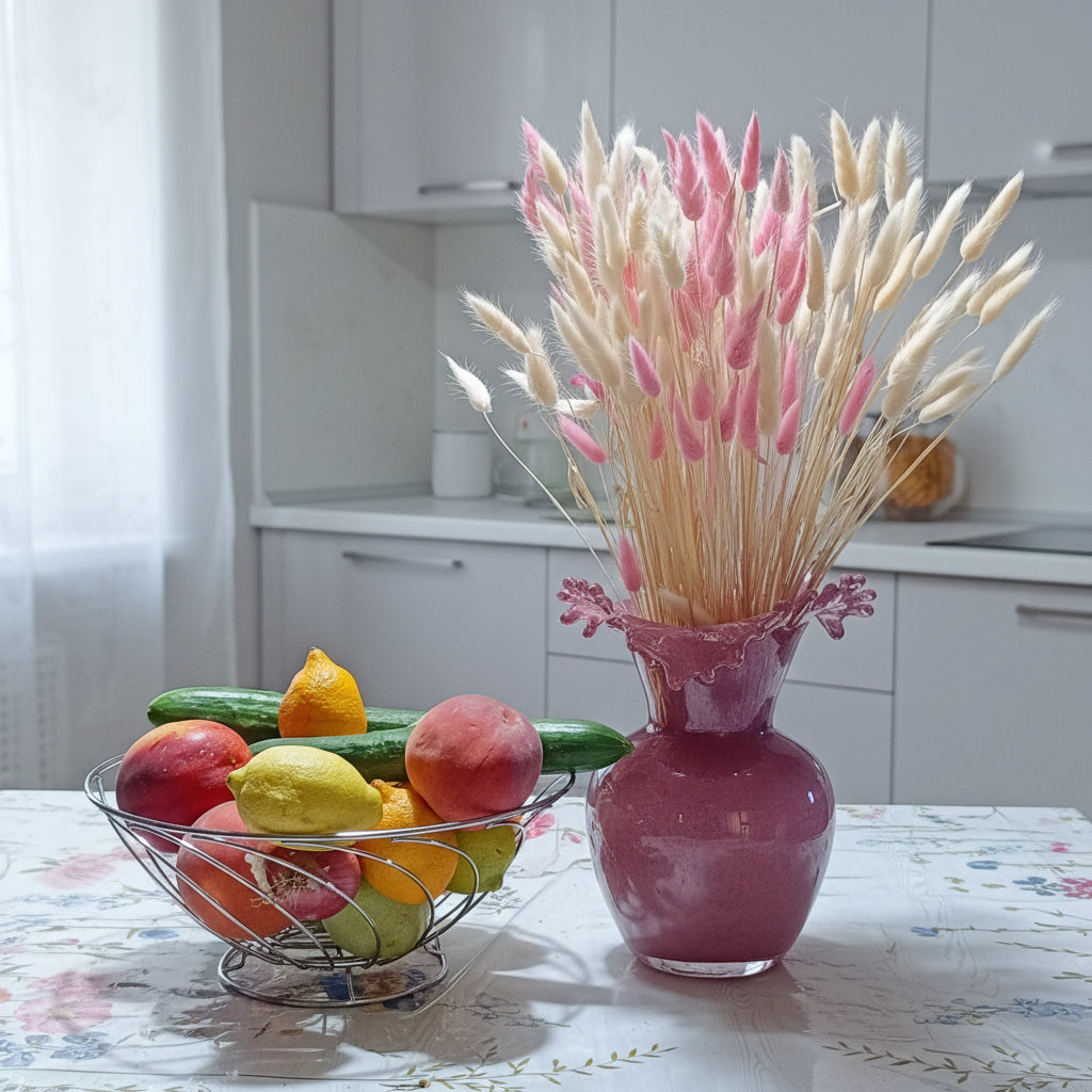 Γυάλινο βάζο μωβ 24cm με ruffled στόμιο με ροζ και λευκό bunny tail grass σε τραπέζι κουζίνας με λουλουδάτο τραπεζομάντιλο και μπολ με φρούτα - VassoHome
