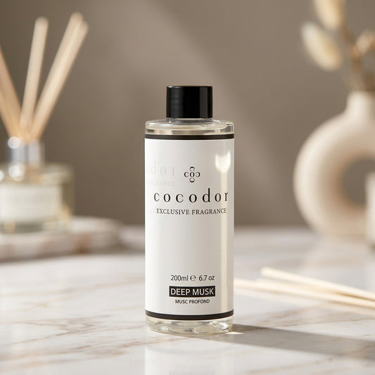 Ανταλλακτικό αρωματικού χώρου Cocodor Deep Musk 200ml σε μαρμάρινη επιφάνεια με diffuser και κεραμικό βάζο στο φόντο - VassoHome