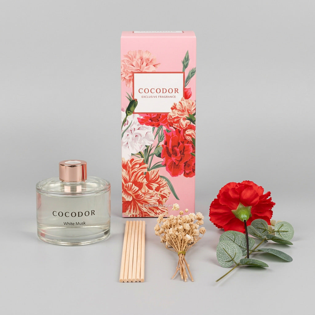 Περιεχόμενα συσκευασίας Cocodor Carnation White Musk με γυάλινο μπουκάλι, ξύλινα sticks, κόκκινο γαρίφαλο και διακοσμητικά κλαδιά σε γκρι φόντο - VassoHome
